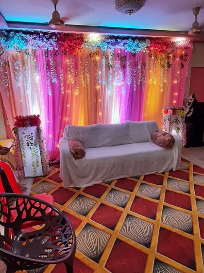 A full view of a living room transformed for a house party. I used a colorful backdrop with hanging flowers and lights to create a festive corner.