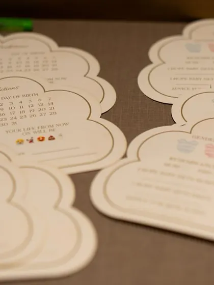 Custom-designed 'Baby Predictions' cards in the shape of clouds for a whimsical baby shower.