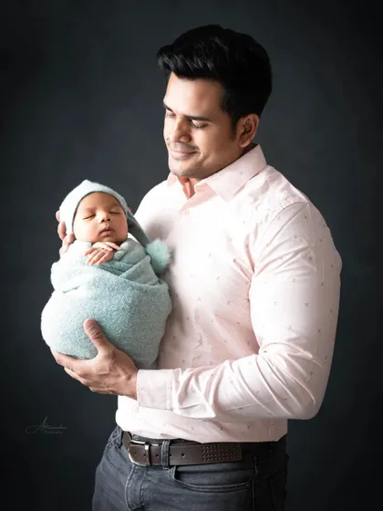 A proud father's gentle hold. These early days are so fleeting, and we're here to preserve them for you.