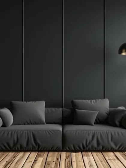 A moody and sophisticated color combination of black walls, wooden floors, and plush grey furniture.