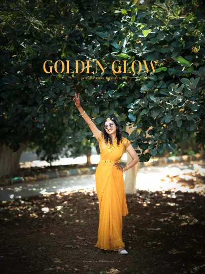 A wide shot of the bride celebrating under a tree, embodying the 'Golden Glow' of the Haldi ceremony.