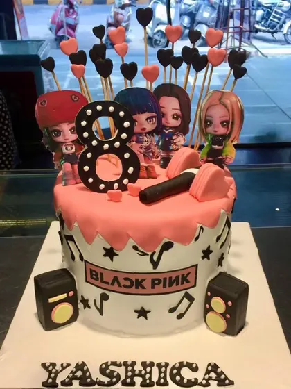 A perfect cake for a K-Pop fan. This Blackpink-themed cake is decorated with music notes, mini speakers, and figures of the band members.