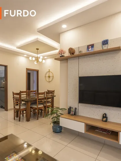 A view of the living area focusing on the custom TV unit. The combination of wood and textured laminate provides a modern look with plenty of hidden storage to keep the space tidy.