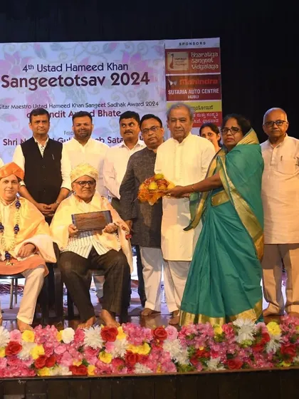 The community coming together to honor the artists and artisans at the Sangeetotsav. This shows the deep respect people have for music and its traditions.