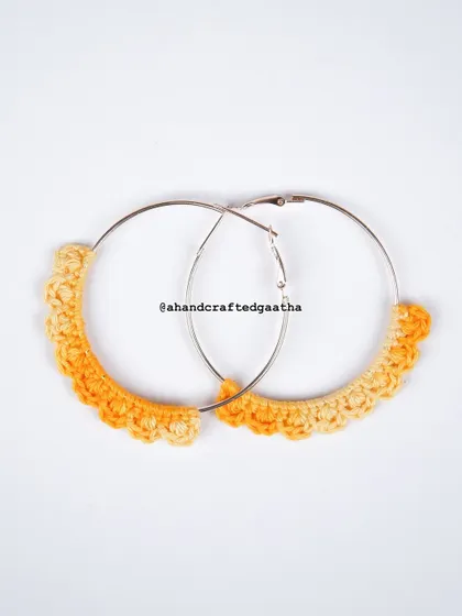 A studio shot of the yellow 'Naazakat' hoops, showing the sunny, two-toned yarn against a clean white background.