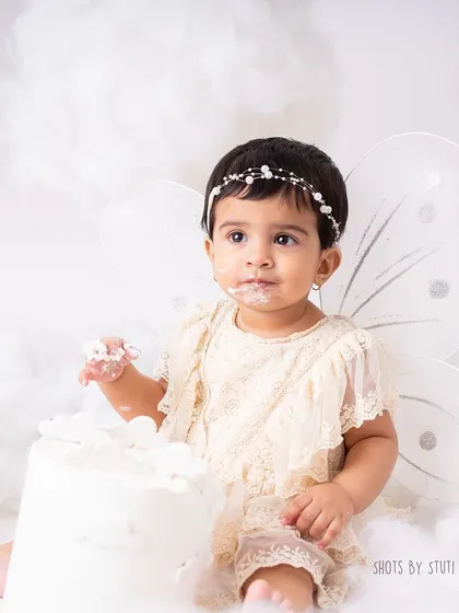 Another adorable moment from the fairy-themed session. The delicate headband and lace romper add to the angelic look, making these photos truly special.