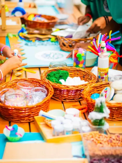 A close-up of the craft station, with baskets of colorful yarn, pom-poms, and other materials for the kids to get creative.