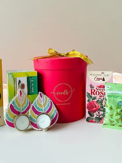 This round red box, branded with our logo, is filled with cookies, tea, beaded t-light holders, and other treats.