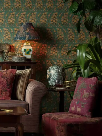 A close-up of the Sabyasachi-designed living space, highlighting the layered textures and patterns of the wallpaper, cushions, and upholstery.