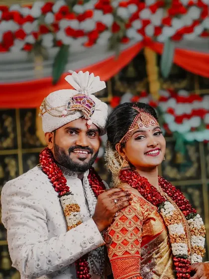 A classic wedding portrait. The couple is dressed in their wedding attire, smiling for the camera, a timeless memory of their special day.