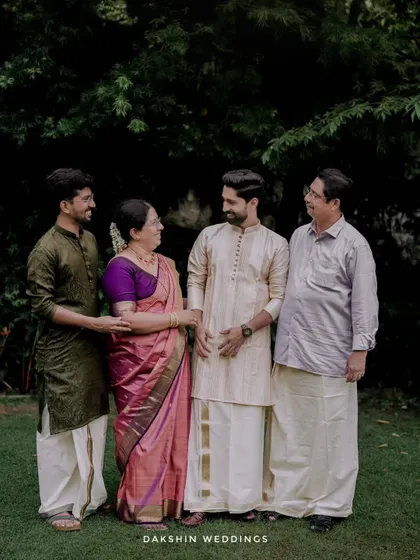 A portrait of the groom with his family, capturing a moment of pride and happiness on the wedding day.