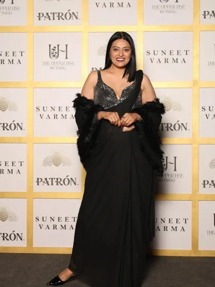 Attending a Suneet Varma showcase in a classic black pre-draped saree with a sequined blouse and a feather stole. This look is all about sophisticated glamour with a touch of drama.
