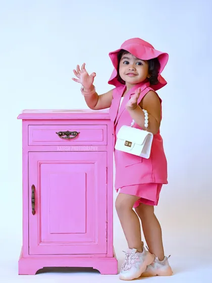 A cute wave to the camera in this stylish kid's portrait.