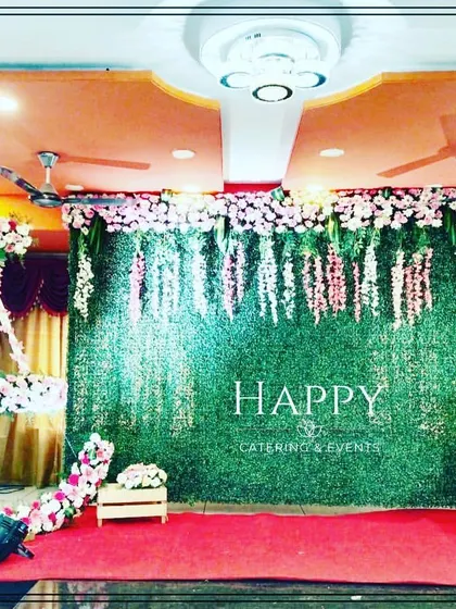 A lovely naming ceremony stage featuring a pink and white floral moon cradle. The backdrop combines a greenery wall with hanging wisteria for a delicate and elegant look.