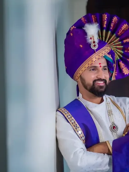A stylish portrait of the groom leaning against a wall, his smile reflecting his happiness and excitement.