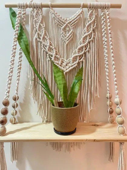 This bohemian macrame floating shelf is perfect for holding your favorite small plant, books, or candles. I make it with off-white cotton cord, wooden beads, and a solid pinewood plank.