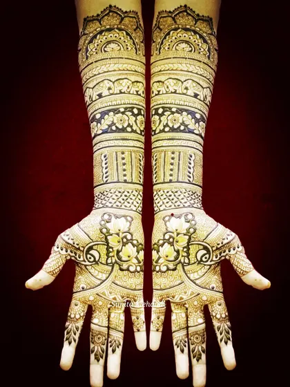 This design is filled with classic bridal motifs. It features bands of elephants, floral patterns, and symmetrical designs on the palms for a traditional look.