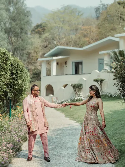 A playful, leading shot taken on the pathways of a lush resort. This kind of interactive pose feels natural and fun, allowing me to capture genuine smiles and movement during a destination couple shoot.