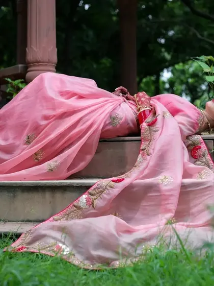 A creative reclining pose on the gazebo steps, with the saree's pallu spread out. This artistic shot highlights the beauty of both the model and the architecture.