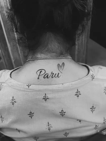 The same "Paru" neck tattoo shown in black and white. This highlights the clean lines of the script and the shape of the design.
