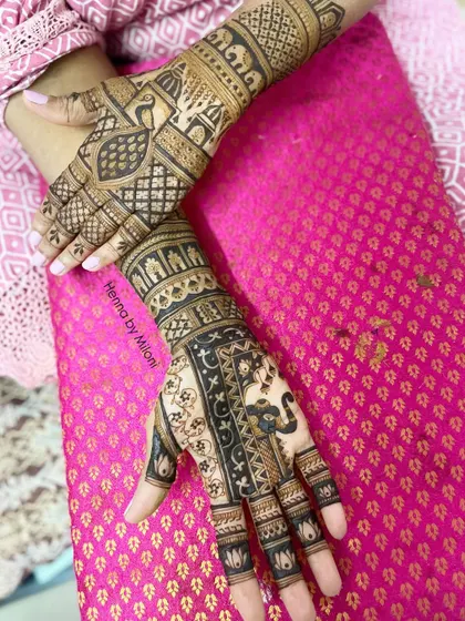 A look at the front and back of a bridal mehendi. The front is intricate with elephants and peacocks, while the back has a simpler, elegant design.