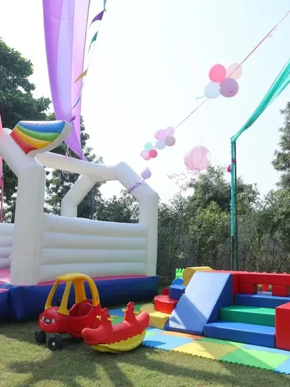 The play area at an outdoor birthday party, complete with a unicorn bouncy castle. I capture all the elements that make the day fun and exciting for the kids.