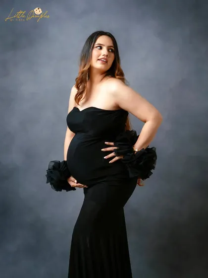 A classic black gown is always a timeless and elegant choice. This portrait focuses on the beautiful silhouette and the confident glow of the mom-to-be.