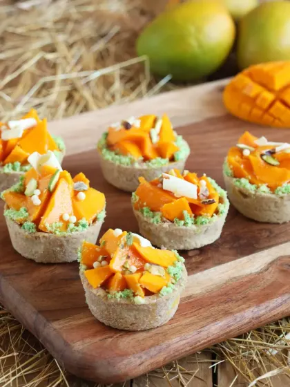 These bite-sized Mango Tarts feature a crispy crust filled with a creamy base and topped with fresh mango and pistachios. They are perfect for parties and high tea.