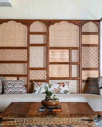 The centerpiece of this living room is the custom-designed sofa with an integrated cane screen, providing a beautiful and functional partition.