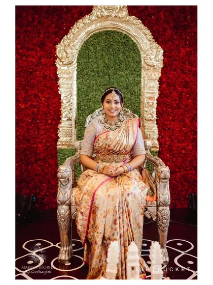 Nidhi Venugopal looking regal for her bangle ceremony. Her makeup is glamorous yet traditional, with a focus on her eyes and flawless skin to complement her ornate saree.