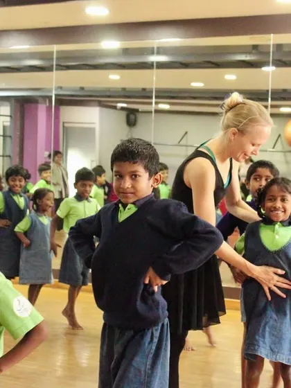 An instructor provides a hands-on correction, helping a student feel the correct posture in his own body.