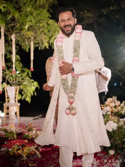 The groom's infectious laughter captured during a happy moment at the wedding.