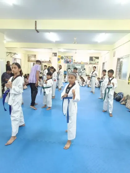 A class of blue belts practicing their forms, showing the progression from beginner levels.