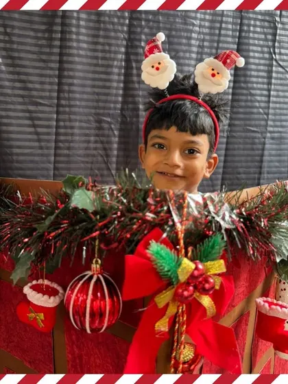 A happy boy in a Santa hat enjoys the festive photo corner. These portraits are a wonderful keepsake from our school celebrations.