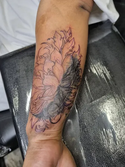 An in-progress shot of the floral cover-up, showing how the dark leaves are filled in first to effectively block out the old tattoo.