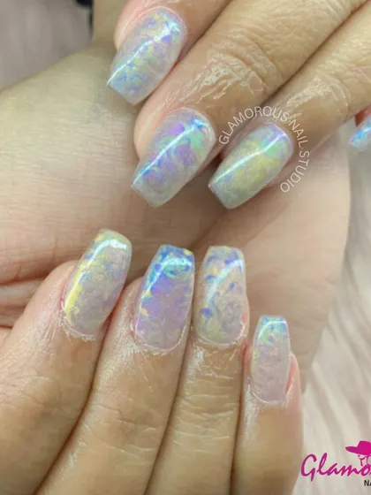 A magical, iridescent look. These nails have a "shattered glass" or "unicorn skin" effect, reflecting a rainbow of pastel colors. It's a dreamy and ethereal design that is truly unique.