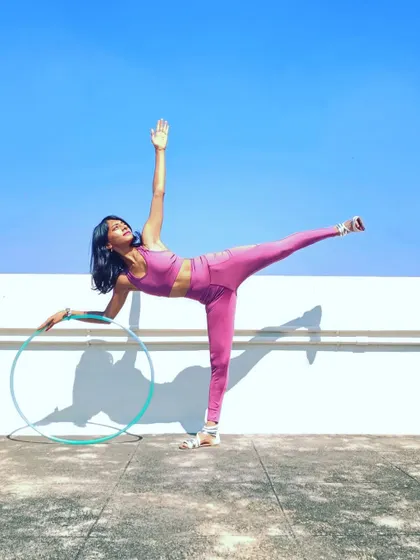 Finding balance in a half-moon pose (Ardha Chandrasana) with my hoop. Yoga teaches me the stability and focus I need for my flow arts practice.