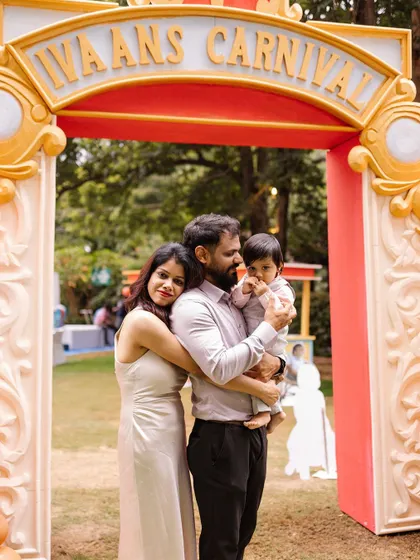 A warm family hug at the entrance of "Ivaan's Carnival." We design grand entrances that make your guests feel like they are stepping into another world.