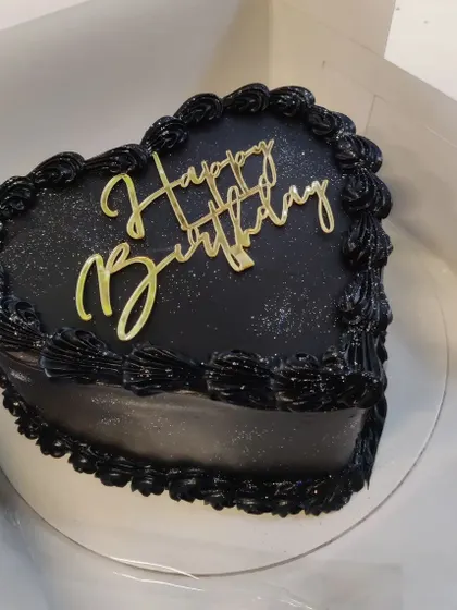 Who says hearts have to be red? This chic black heart-shaped birthday cake proves that it's the heart that matters. A simple, elegant, and modern choice for any celebration.