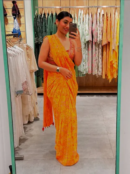 Here I am in a vibrant orange printed saree. This look shows how a simple, well-draped saree can be a powerful statement for any festive occasion.