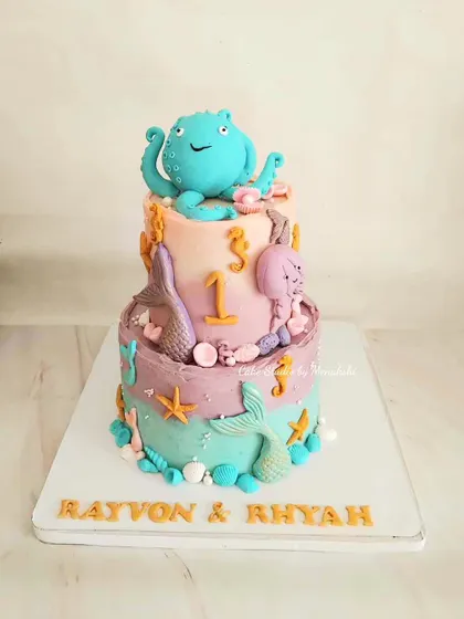 A magical two-tier sea themed cake for twins celebrating their first birthday. I loved creating the pastel colors and the little octopus, seahorses, and mermaid tails.