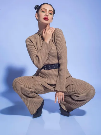 A winter fashion editorial featuring a ribbed knit co-ord set. I used a simple blue background and dynamic poses to highlight the texture and silhouette of this chic and comfortable winter outfit.