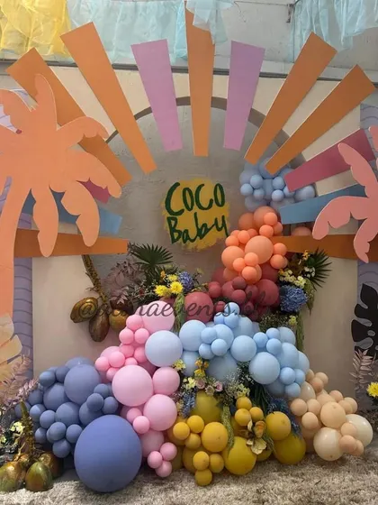 Another angle of the vibrant "Coco Baby" shower backdrop. This shot shows the rich colors of the balloon and floral arrangement, creating a lush and tropical photo corner.
