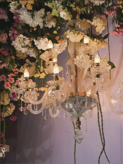 A close-up of a crystal chandelier dripping with flowers. This detail shows how I blend classic luxury with natural beauty to create unique and stunning decor pieces.