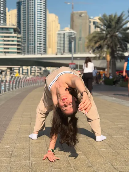 A wide-legged forward bend, showing my flexibility. I incorporate deep stretches into my warm-ups to ensure all my students and clients dance safely and improve their range of motion.
