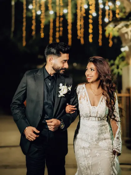 The couple sharing a happy moment while walking arm-in-arm at their evening reception. I use the background lighting to create a beautiful bokeh effect.