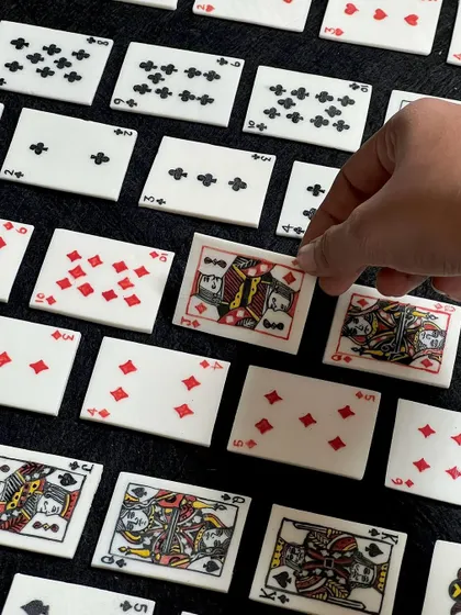 A close-up of the intricately detailed ceramic playing cards. The level of craftsmanship is just insane.