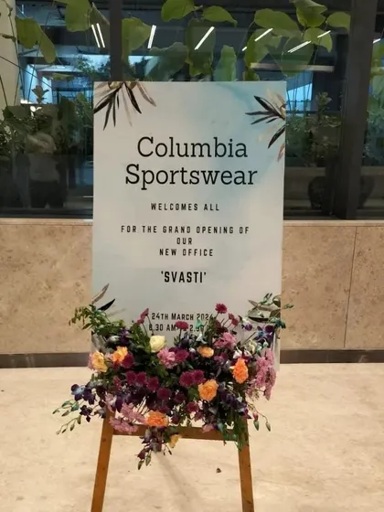 This welcome easel for Columbia Sportswear, placed inside the building, reinforces the event's branding and theme. The floral arrangement at the base adds a touch of elegance to the functional signage.