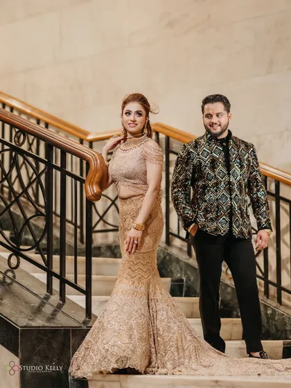 A stylish portrait of the couple on a grand staircase, looking elegant and happy.