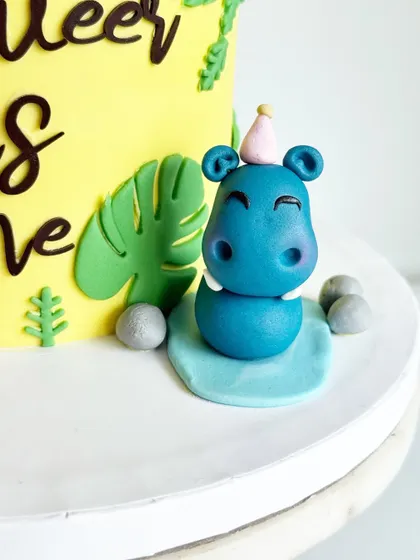 A smiling hippo topper, ready for a party! These small details are what make a custom cake so memorable.